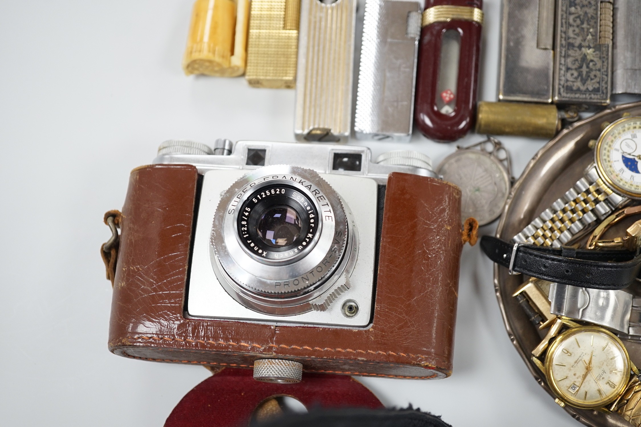 A collection of mixed wristwatches and cigarette lighters and a camera